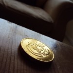 1253358_gold_coin_on_wooden_table[1]
